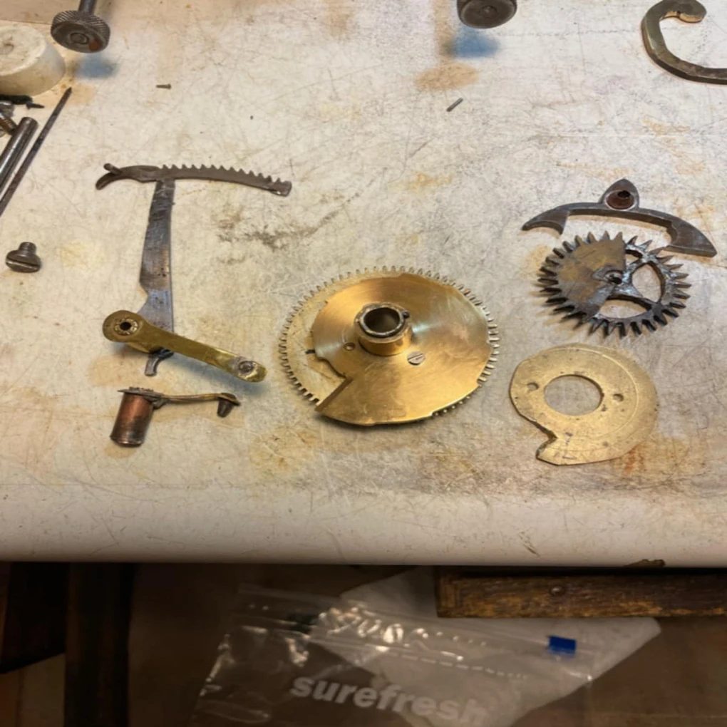 Clock movement gears and parts laid out for reassembly